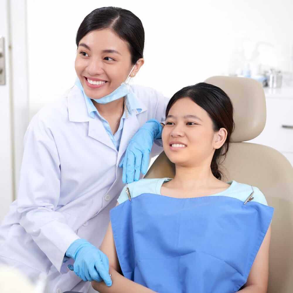 asian-female-dentist-patient-sitting-together-looking-something painless wisdom tooth extraction